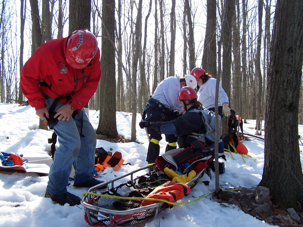 Winter missing person rescue. Hooking up a rescue basket on snow