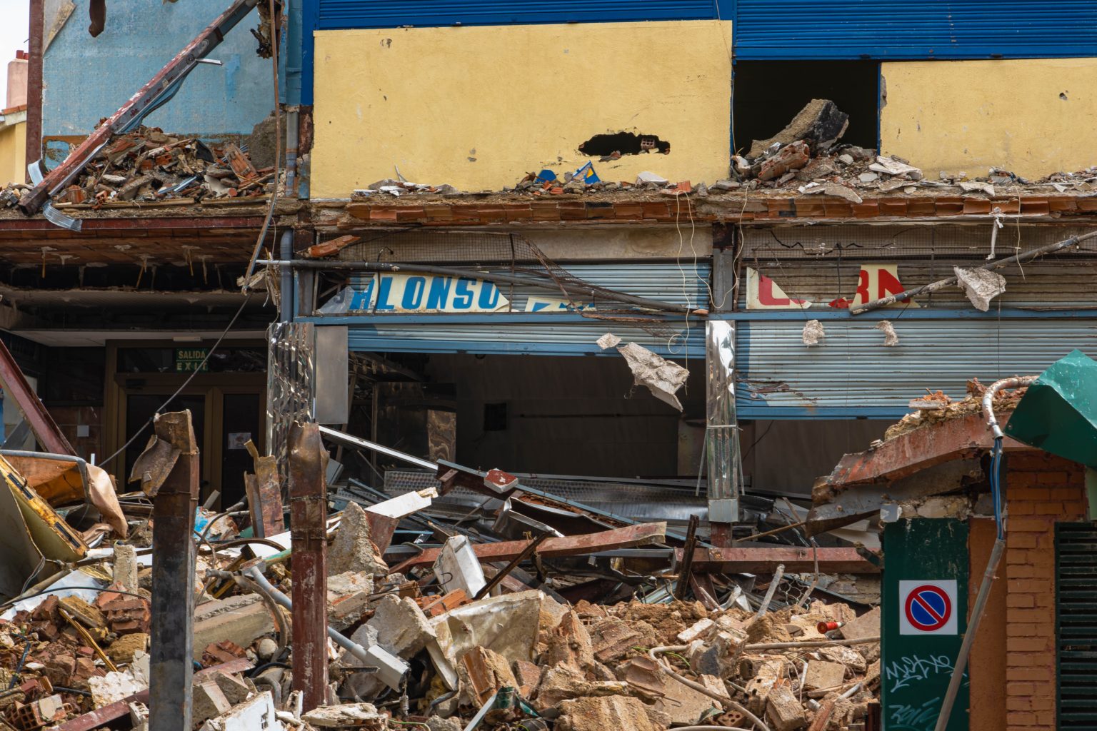 Business damage from earthquake. Rubble piled in front.